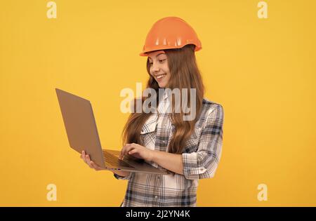 Happy teen Mädchen in Helm und karierte Shirt mit Laptop, Bildung Stockfoto