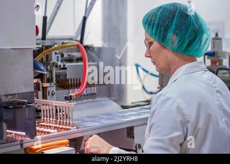 Roboterarm Zum Anheben Von Ampoules An Der Verpackungslinie In Der Pharmafabrik. Pharmazeutische Fertigung. Stockfoto