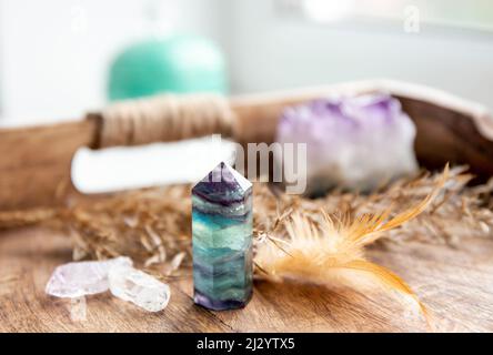 Durchscheinender Fluorit Kristall Stehpunkt Edelstein im Schlafzimmer auf natürlichem Holztablett. Heilendes und klärendes Energiekonzept. Stockfoto
