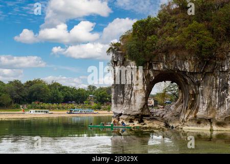 Guilin, China.  Elephant Trunk Hill Park, Mond Arch.  Li-Fluss Kreuzfahrt Boote im Hintergrund. Stockfoto