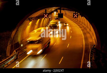 Autos und Lastwagen, die nachts in einem Tunnel fahren Stockfoto
