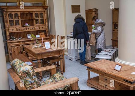 Moskau, Russland. 3.. April 2022. Ein Paar betrachtet Holzmöbel im belarussischen Laden auf dem Territorium des Ausstellungs- und Handelszentrums der Republik Belarus (Pavillon Nr.18) auf dem VDNKh in Moskau, Russland Stockfoto