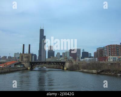 Skyline von Chicago vom Ufer des Chicago River unter leicht bewölktem Himmel Stockfoto