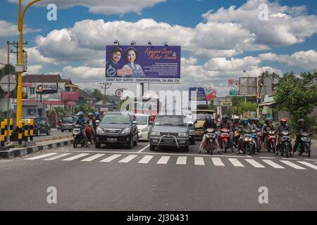 Yogyakarta, Java, Indonesien.  Motorräder und Autos an Kreuzung, warten auf Licht zu ändern. Stockfoto