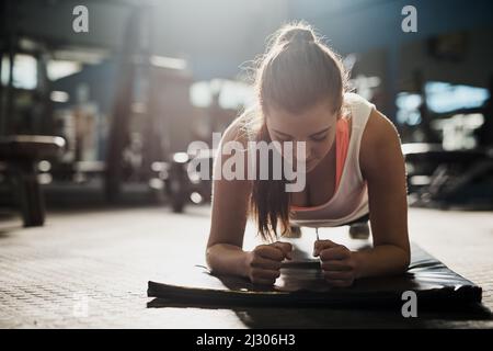 Bleiben Sie Ihren Entscheidungen verpflichtet. Aufnahme einer jungen Frau, die im Fitnessstudio arbeitet. Stockfoto