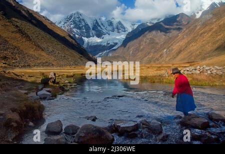 Peruanische Frau auf Trittsteinen in der Cordillera Huayhuash, Peru Stockfoto