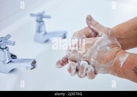 Halten Sie Ihre Hände sauber. Aufnahme eines unverkennbaren Mannes, der sich zu Hause die Hände mit Seife wusch. Stockfoto