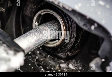 Metall-Kraftstoffdüse, Füllen des Gastanks des Autos mit Schnee im Winter bedeckt, Nahaufnahme Detail Stockfoto