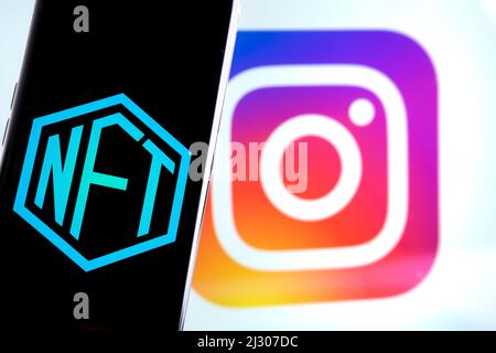 NFT-Logo auf dem Smartphone und verschwommenes Instagram-Logo auf dem Hintergrund. Konzept für Instagram als neuen NFTs-Marktplatz. Stafford, Großbritannien, A Stockfoto