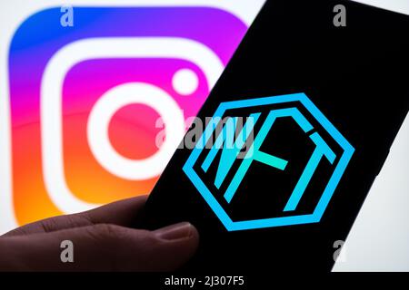 NFT-Logo auf dem Smartphone und verschwommenes Instagram-Logo auf dem Hintergrund. Konzept für Instagram als neuen NFTs-Marktplatz. Stafford, Großbritannien, A Stockfoto