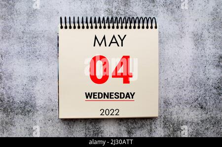 Mai 4. 4. Tag des Monats, Kalenderdatum. Ständer für Desktop-Kalender auf beigefarbenem Holzhintergrund. Konzept des Tages des Jahres, Zeitplaner, Frühlingsmonat. Stockfoto