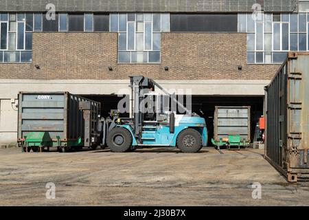 Walbrook Wharf Container Dock. Nahaufnahme eines Gabelstaplers, der einen Lagerbehälter bewegt. London - 12.. März 2022 Stockfoto
