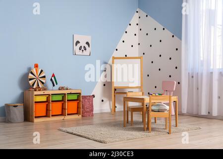 Einrichtung eines stilvollen Kinderzimmers mit Tisch und Flagge der Vereinigten Arabischen Emirate Stockfoto