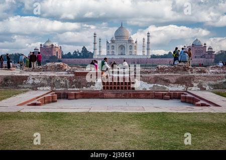 Agra, Indien. Die Menschen genießen den Blick auf den Taj Mahal von den Mehtab Bagh Gardens, auf der gegenüberliegenden Seite des Yamuna River. Stockfoto