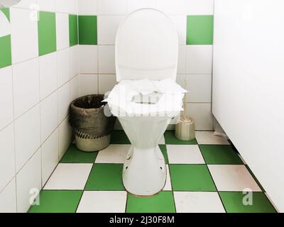 Der Toilettensitz in einer öffentlichen Toilette ist mit Papierservietten bedeckt. Stockfoto