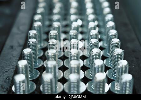 Viele Metallschrauben als Hintergrund für Industrieanlagen. Stockfoto