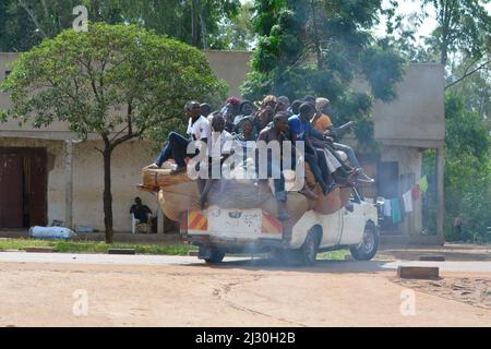 Uganda; Zentral-Uganda im Nakasongola District; auf der Straße von Kampala nach Masindi in der Nähe von Nakitoma; voll beladenes Buschtaxi; Passagiere sitzen auf der Rückseite des Gepäcks Stockfoto