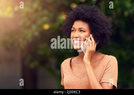 Ich fühle mich in der Natur so verbunden. Aufnahme einer jungen Frau, die auf ihrem Handy spricht, während sie den Tag im Freien verbringt. Stockfoto