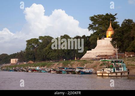 Myanmar, Burma. Buddhistische Stupa und lokale Boote auf dem Ayeyarwady (Irrawaddy) River Bank. Stockfoto