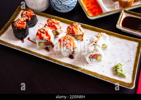 Im Restaurant wird ein köstliches Sushi-Set auf dem Teller serviert Stockfoto