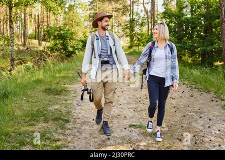 Junges Paar, das gemeinsam im Wald die Hände hält Stockfoto