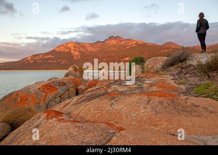 Frau auf Fotheringate Bay, mit Blick auf die Strzelecki Peaks Stockfoto