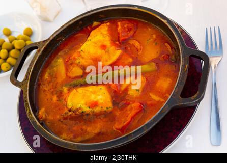 Gebackene Merluse mit Gemüse und Tomatensauce Stockfoto