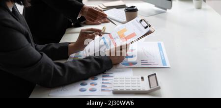 Team von Geschäftsleuten, die im Büro des Besprechungsraums zusammenarbeiten, Hintergrunddiagramme und Grafiken für Teamarbeit, doppeltes Engagement erfolgreiche Teamarbeit Stockfoto