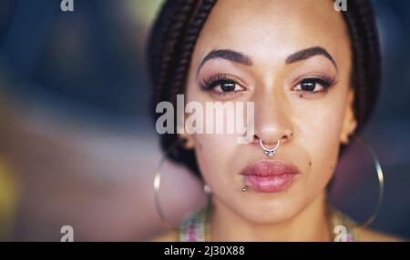 Für Mut. Porträt einer attraktiven jungen Frau mit Piercings. Stockfoto