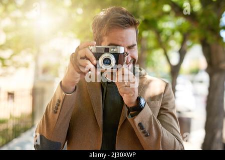 Sagen Sie Käse. Ausgeschnittene Aufnahme eines hübschen jungen Mannes, der während seiner morgendlichen Fahrt fotografiert. Stockfoto
