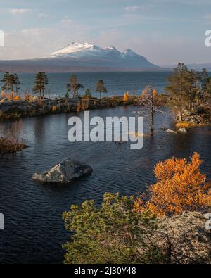 Landschaft mit verschneiten Bergen des Sarek National Park und See im Stora Sjöfallet National Park im Herbst in Lappland in Schweden Stockfoto