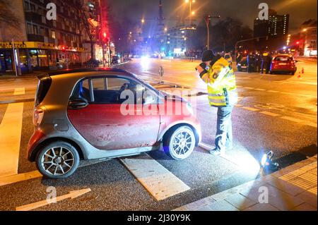 Hamburg, Deutschland. 04. April 2022. Ein Verkehrsunfall-Ermittler macht ein Foto des Autos, das an dem Unfall beteiligt ist. Ein älterer Autofahrer traf einen Polizisten mit seinem Auto während einer Unfalluntersuchung am Montagabend. Der Polizist erlitt Verletzungen und wurde in ein Krankenhaus gebracht, sagte ein Sprecher am Dienstagabend. Die genauen Umstände des Unfalls müsse nun ermittelt werden, sagte er. Quelle: Jonas Walzberg/dpa/Alamy Live News Stockfoto