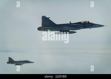 Zwei tschechische Luftstreitkräfte Saab JAS-39C Gripens begleiten eine B-52H-Stratofortress, die der Expeditionary Bomb Squadron 69. bei RAF Fairford, England, zugewiesen wurde, 31. März 2022. Die 69. EBS flog in die Tschechische Republik, um sich mit den US-Alliierten zu integrieren, um sich im Rahmen der vorgeplanten Bomber Task Force Europe-Missionsreihe mit Bombern vertraut zu machen. (Air Force Courtesy Photo) Stockfoto