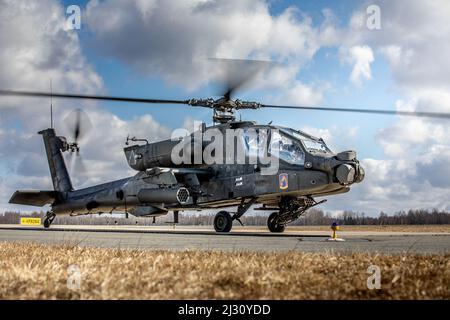 US-Armee 1.. LT. Jacob Kelley und Chief Warrant Officer 4 Joe Lorman, Apache-Hubschrauberpiloten, beauftragt mit dem 1-3. Angriffsbataillon, 12. Combat Aviation Brigade, führt einen Pre-Flight Check auf der Lielvarde Air Base, 3. April 2022 durch. 12 CAB ist unter anderem dem V Corps, dem amerikanischen Forward Deployed Corps in Europa, zugewiesen, das mit NATO-Alliierten und regionalen Sicherheitspartnern zusammenarbeitet, um kampfbereite Truppen bereitzustellen, gemeinsame und multinationale Trainingseinheiten durchzuführen und das Kommando und die Kontrolle für alle rotatorischen und zugewiesenen Einheiten im Europäischen Theater behält. (USA Armeefoto von Sgt. Preston Stockfoto