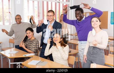 Fröhliche Menschen, die Schutzmasken ausziehen Stockfoto