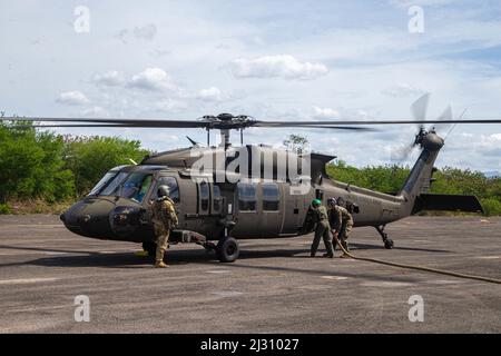 US-Marineinfanteristen, die dem Marine Wing Support Squadron 172 (MWSS-172) zugewiesen wurden, und ein Soldat der Armee mit der 25. Combat Aviation Brigade, 25. Infantry Division, tanken während der Balikatan 22 in Subic Bay, Philippinen, am 3. April 2022 einen Army UH-60 Hawk Hubschrauber an einem Vorwärts-Bewaffnungs- und Betankungspunkt auf. Balikatan ist eine jährliche Übung zwischen den Streitkräften der Philippinen und dem US-Militär, die darauf ausgerichtet ist, bilaterale Interoperabilität, Fähigkeiten, Vertrauen und Zusammenarbeit zu stärken, die über Jahrzehnte gemeinsamer Erfahrungen aufgebaut wurde. Balikatan, Tagalog für ‘„Schulter an Schulter“, ist eine seit langem bestehende bilaterale Übung b Stockfoto