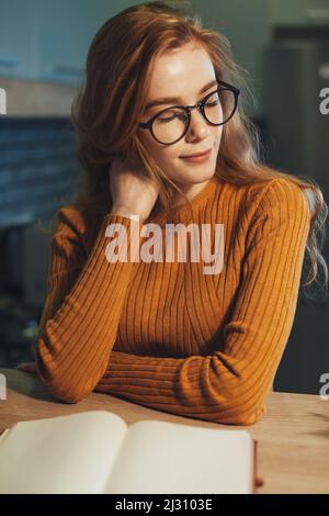 Elegante Ingwer Mädchen Buch am Morgen am Tisch sitzen zu lesen. Porträt einer Geschäftsfrau. Stockfoto