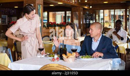 Freundin trifft untreuen Mann im Restaurant Stockfoto