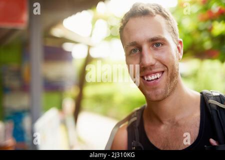 Liebend Rucksacktouristen Leben. Porträt eines lächelnden jungen Mannes, der einen Rucksack trägt und durch Thailand reist. Stockfoto