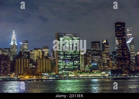 NEW YORK - USA, 5. Okt 2017: Panoramablick auf New York bei Nacht mit UN-Gebäude und beleuchtetem Chrysler Tower und Spiegelungen im Hudson River. Stockfoto