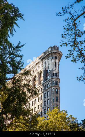 NEW YORK, USA - 5. Okt 2017: Detail des Flatiron-Gebäudes aus dem Park am Broadway in New York unter blauem Himmel. Stockfoto