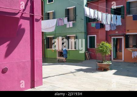 Blick auf Gasse mit Wäscheleine zwischen bunten Hausfassaden, Burano Fischerinsel, Venedig, Venetien, Italien, Europa Stockfoto