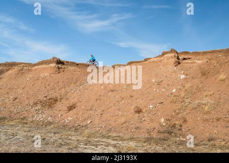 Ein Radler fährt auf einem Schotterfahrrad am Klippenrand in der Colorado Prairie - Naturgebiet Soapstone Prairie Stockfoto