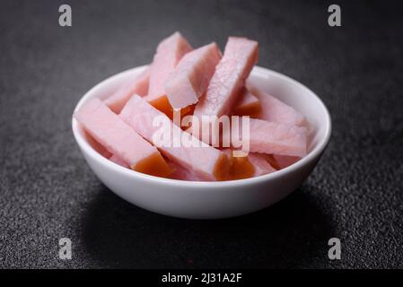 Frischer, köstlicher Twist mit Säulen und Würfeln für Erbsencremesuppe auf schwarzem Betonboden geschnitten Stockfoto