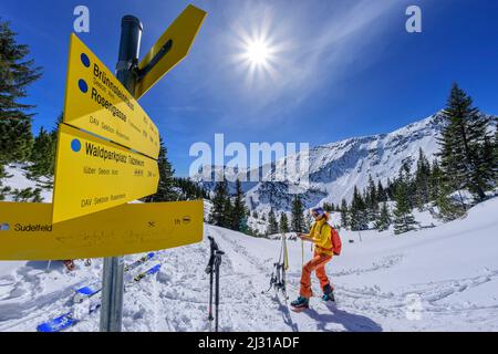 Frau auf Skitour macht Pause am Wanderschild, großer Traithen, Mangfallgebirge, Bayerische Alpen, Oberbayern, Bayern, Deutschland Stockfoto