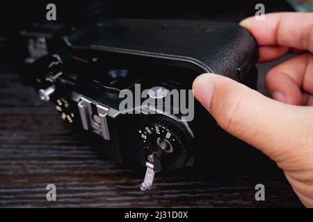 Die Rückseite der Vintage-Filmkamera wird von technischer Hand geöffnet Stockfoto