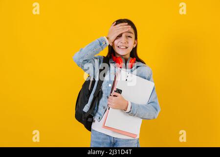 Porträt eines jungen hispanischen Kindes Teenager-Studentin mit besorgten Ausdruck auf einem gelben Hintergrund in Mexiko Lateinamerika Stockfoto
