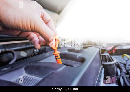 Auto Mechaniker Hand zieht den Ölmessstab für die Überprüfung Schmierstand in der Auto-Reparatur-Garage mit Kopierer Platz Stockfoto