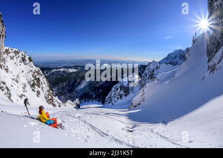 Eine Frau auf Skitour macht eine Pause in einem großen Schneewagen, Zwiesel, Chiemgauer Alpen, Oberbayern, Bayern, Deutschland Stockfoto