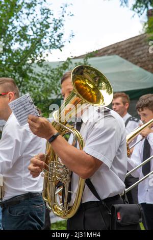 Porąbka, Polen - 8. August 2021. Blaskapelle, Straßenkinder. Amateurmusiker in weißen Hemden spielen während eines Live-Konzerts Blasinstrumente. Stockfoto